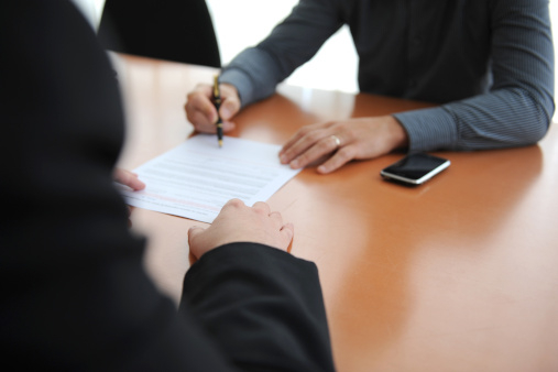 2 personnes signant un contrat
